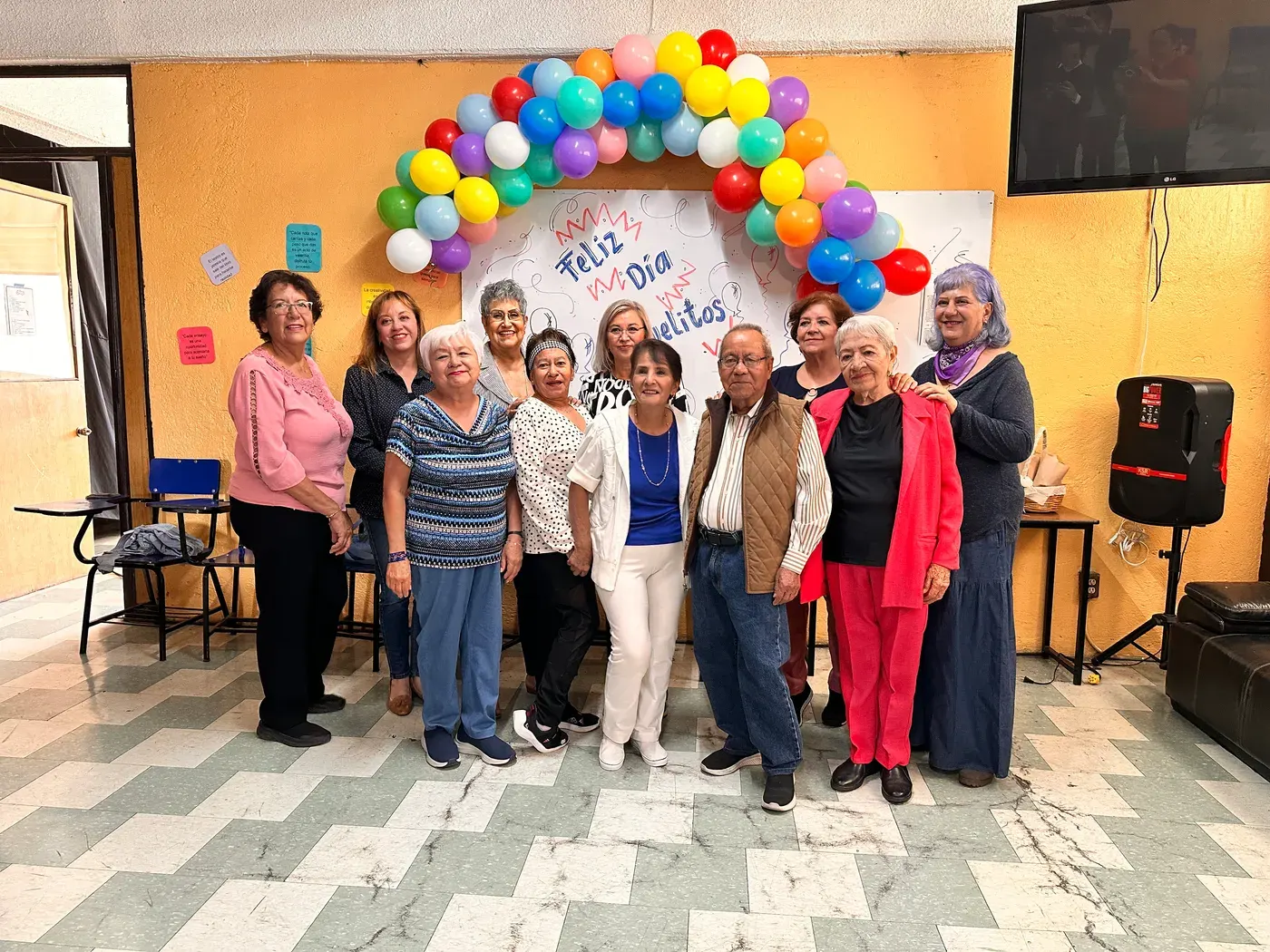 Festejo de la comunidad del Centro AM CADE bajo un arco de globos