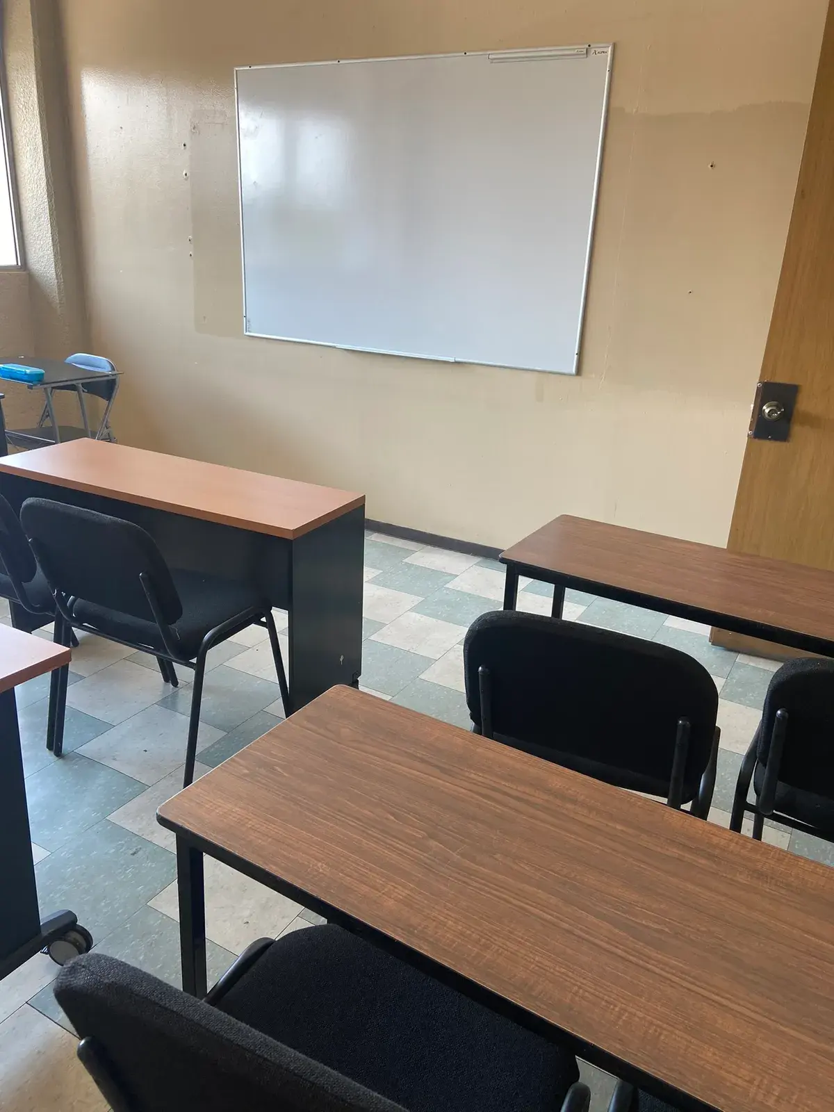 Aula de CADE con mesas de trabajo, sillas y pintarrón blanco