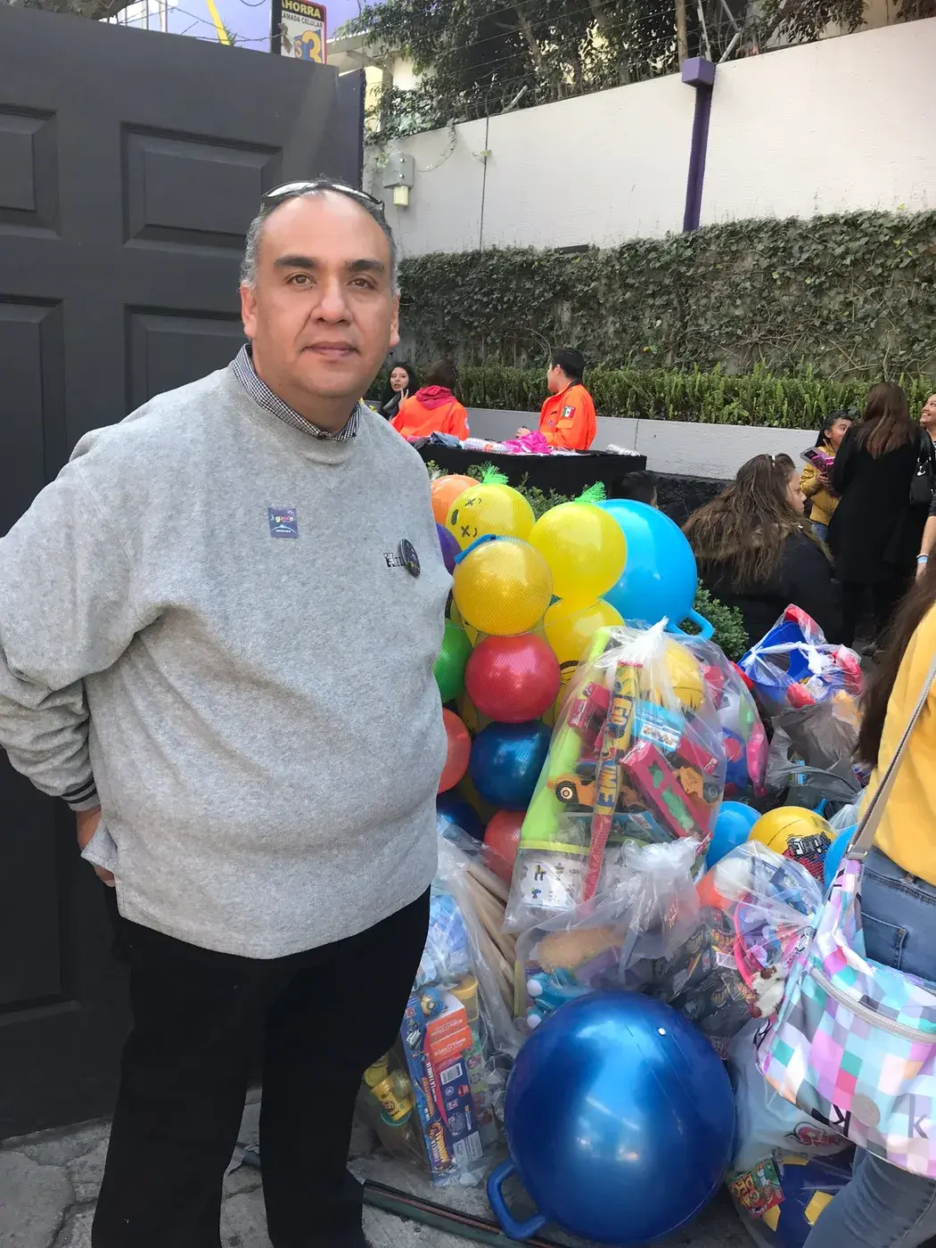 Voluntario junto a una pila de juguetes recolectados para el Juguetón Azteca