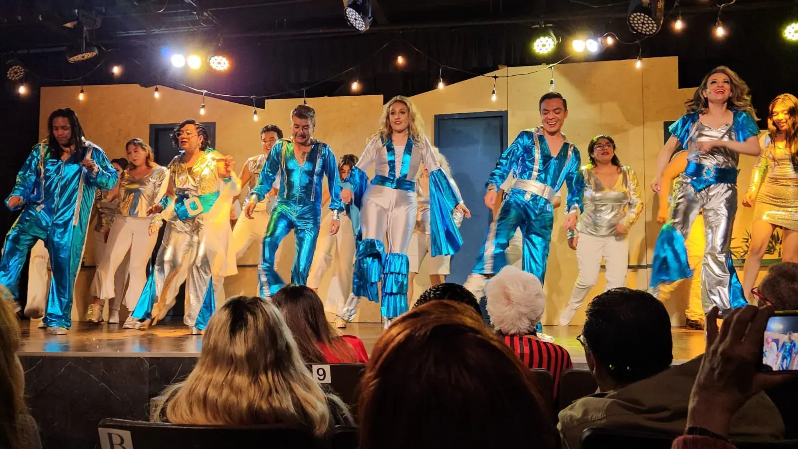 Número musical con vestuario azul y plata ante el público